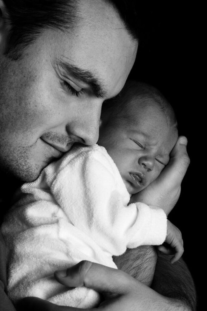 Men Carrying a Baby Greyscale Photography