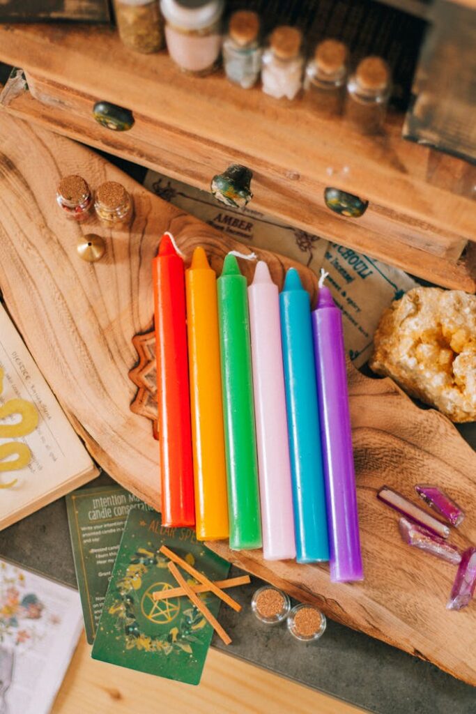 A table with a rainbow colored candle and other items